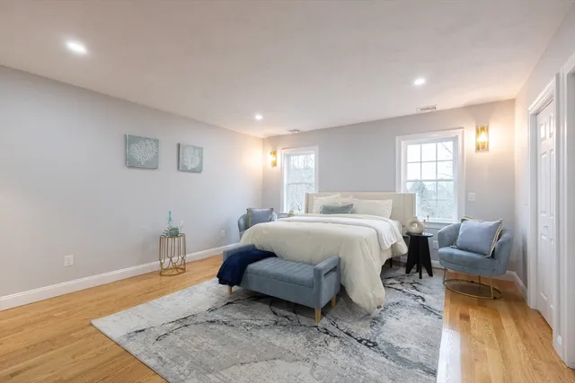 a spacious bedroom with a bed a table and chair