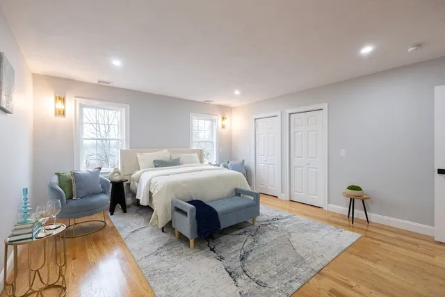 a spacious bedroom with a bed a couch and a window