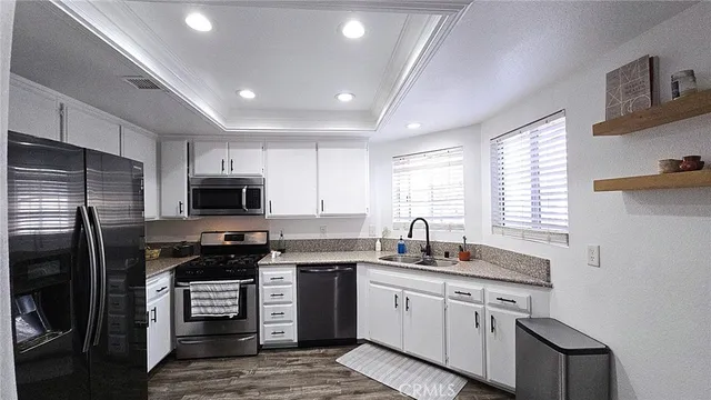a kitchen with kitchen island granite countertop a sink stainless steel appliances and cabinets