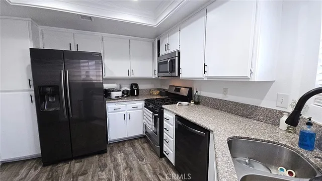 a kitchen with stainless steel appliances granite countertop a refrigerator sink and cabinets