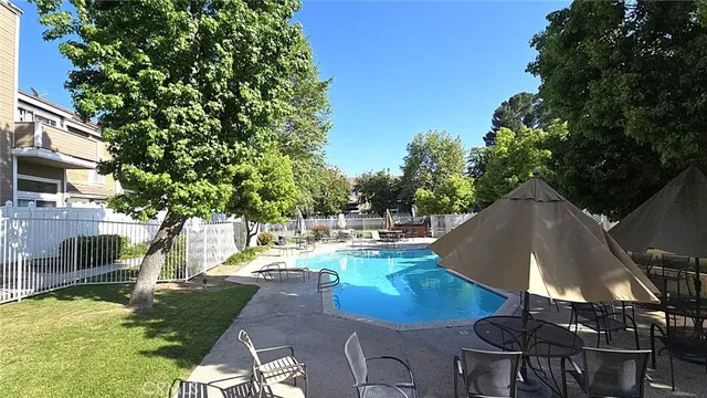 a view of a patio with a dining table and chairs with wooden floor and fence
