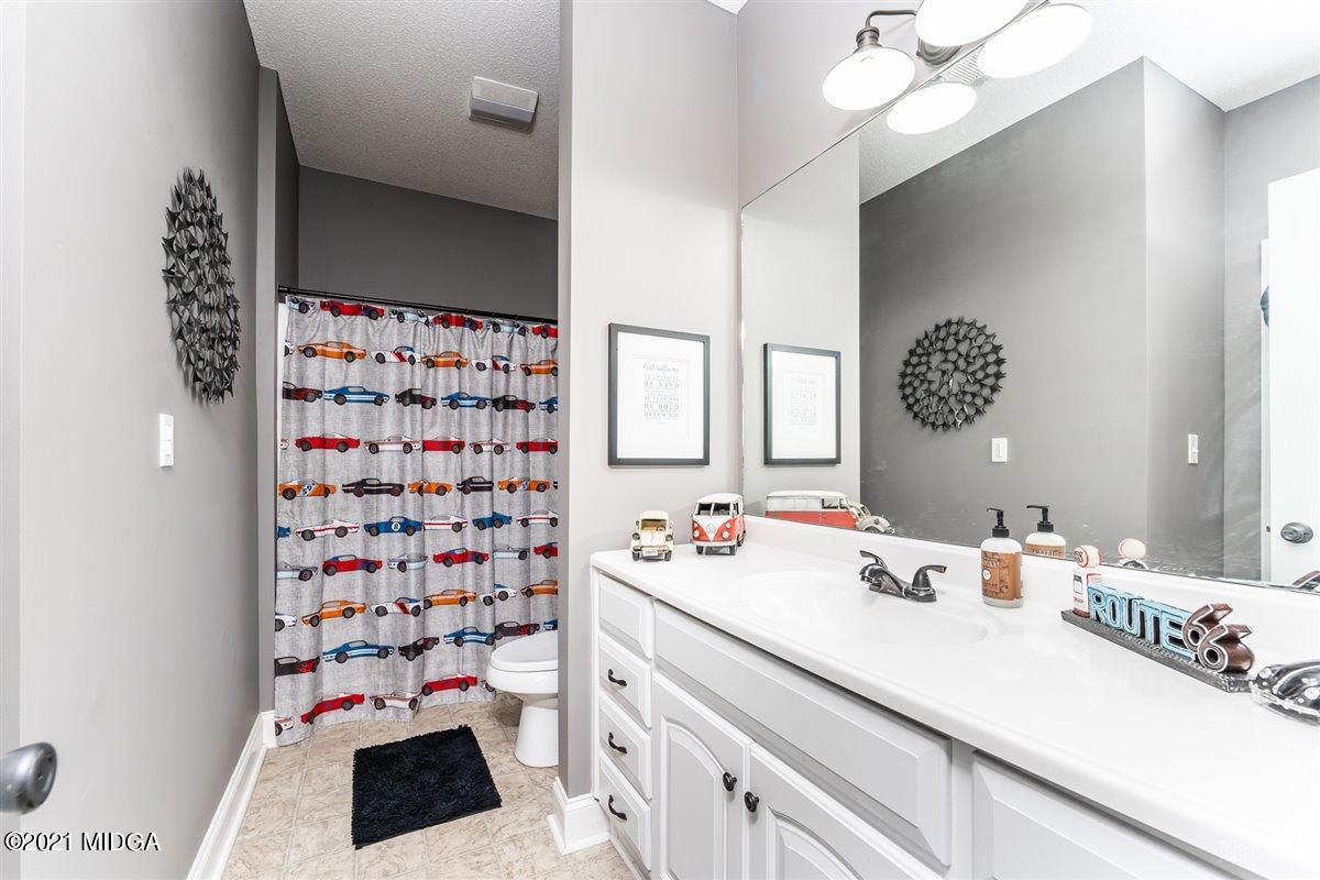 1900 Smith Road Forsyth, GA 31029 - Photo 17 of 28 a bathroom with a sink a large mirror and a shower