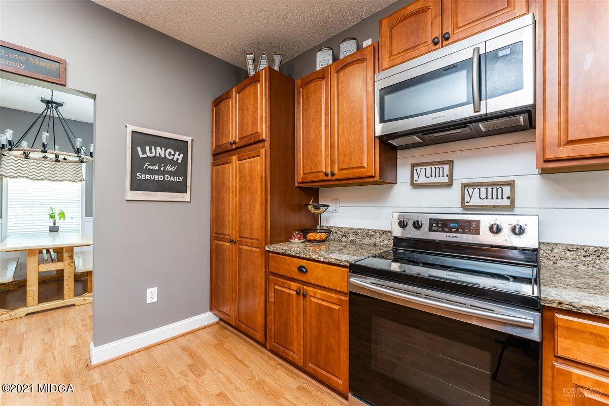 1900 Smith Road Forsyth, GA 31029 - Photo 4 of 28 a kitchen with stainless steel appliances granite countertop a stove a refrigerator and a microwave