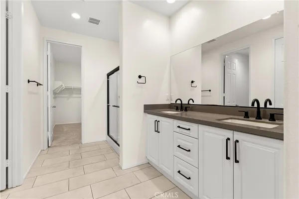 a spacious bathroom with a granite countertop sink a mirror and shower