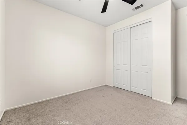 an empty room with a ceiling fan and a window