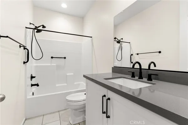 a bathroom with a granite countertop sink a toilet and shower