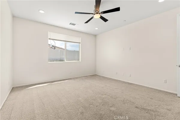 an empty room with a window and a fan
