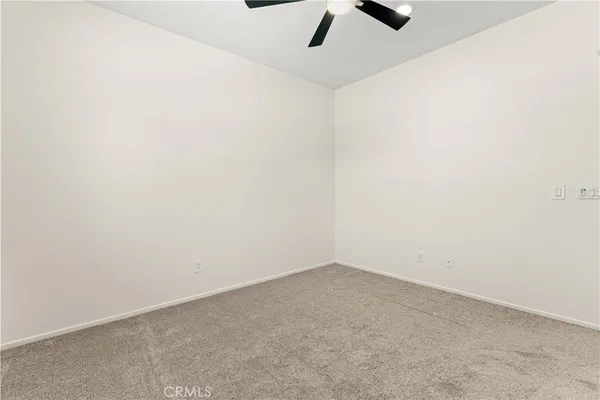 an empty room with a ceiling fan and window