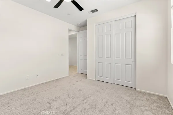 an empty room with chandelier fan