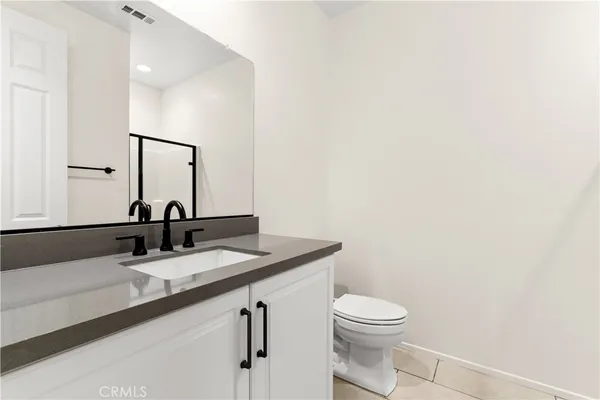 a bathroom with a granite countertop sink a toilet and a mirror