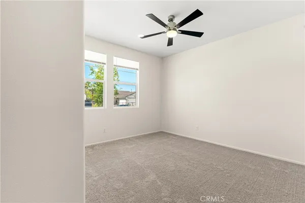 an empty room with a window and a fan
