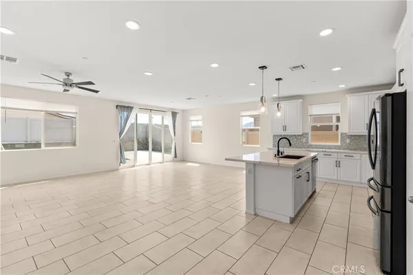 a large white kitchen with a large window cabinets and stainless steel appliances