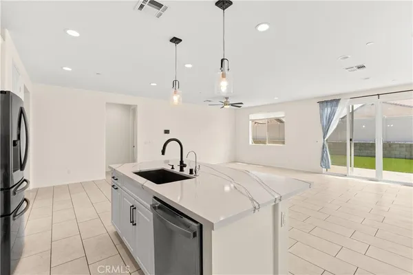 a kitchen with stainless steel appliances granite countertop a sink a oven a refrigerator and a counter top space