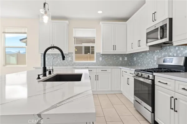 a kitchen with kitchen island a sink stainless steel appliances and cabinets