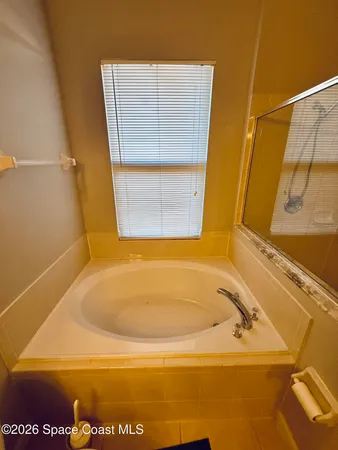 a view of an empty room with a floor to ceiling window and wooden floor
