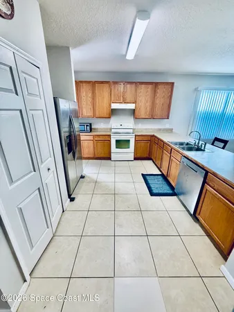 a kitchen with stainless steel appliances a sink a counter top space and a window