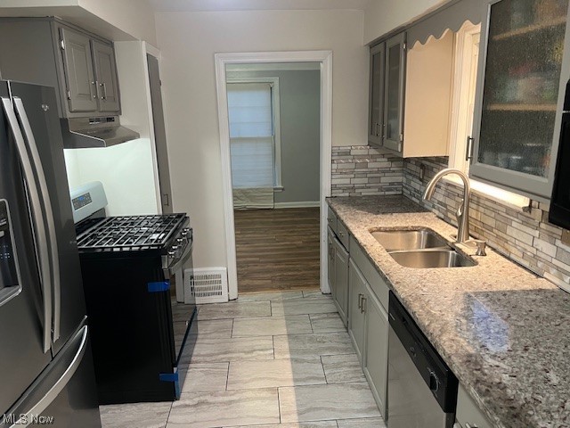 13623 Thraves Road Garfield Heights, OH 44125 - Photo 6 of 23 Kitchen featuring appliances with stainless steel finishes, extractor fan, gray cabinets, backsplash, and sink