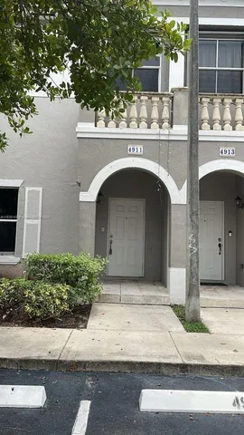 a front view of a house with garage and plants
