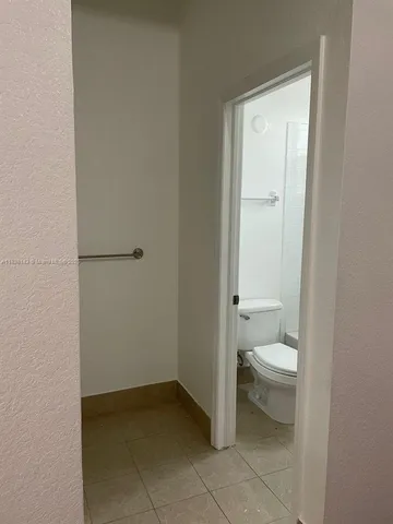 a bathroom with a granite countertop toilet and a sink