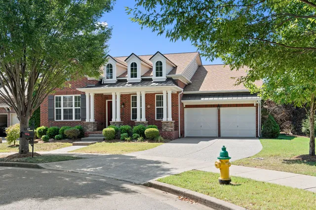 a front view of a house with a yard and potted plants