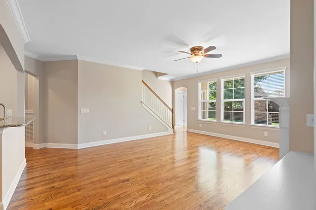 a view of an empty room with window and wooden floor