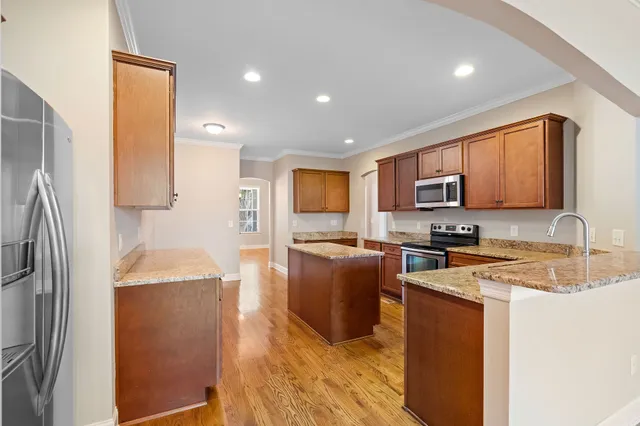 a kitchen with stainless steel appliances granite countertop a refrigerator stove microwave and sink