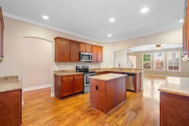 a large kitchen with stainless steel appliances granite countertop a stove a sink dishwasher and a refrigerator