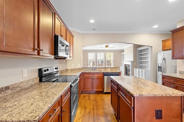 a kitchen with stainless steel appliances granite countertop sink stove top oven and cabinets