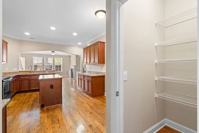 a living room with stainless steel appliances furniture a rug and a kitchen view