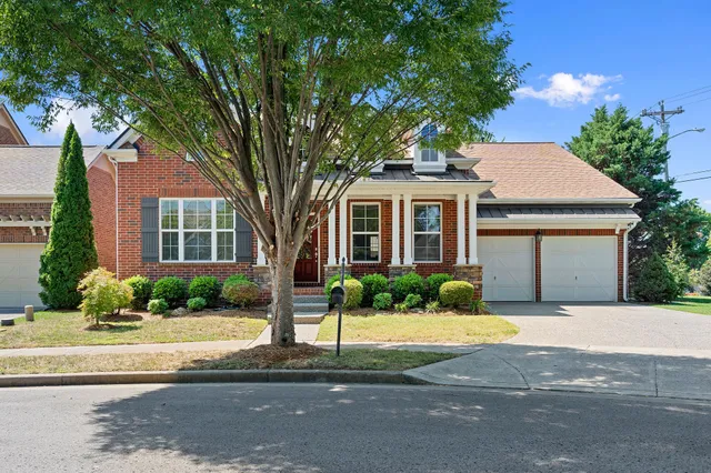 a front view of a house with a yard and potted plants