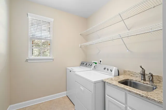 a utility room with sink dryer and washer