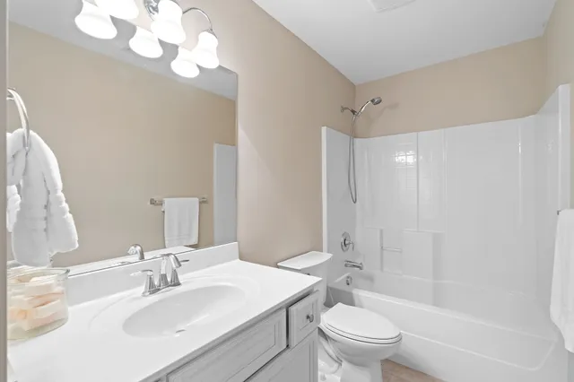 a bathroom with a sink a toilet and a large mirror