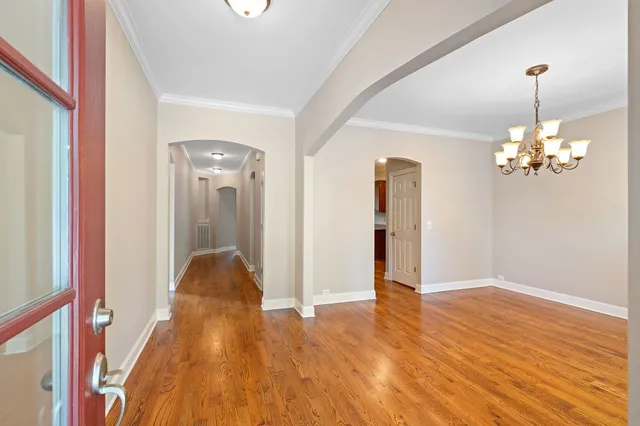 a view of a room with wooden floor and chandelier