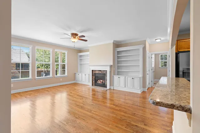 a view of an empty room with a window and fireplace
