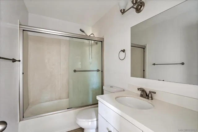 a bathroom with a sink mirror toilet and shower