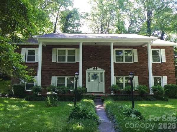 a view of a house with a yard and potted plants