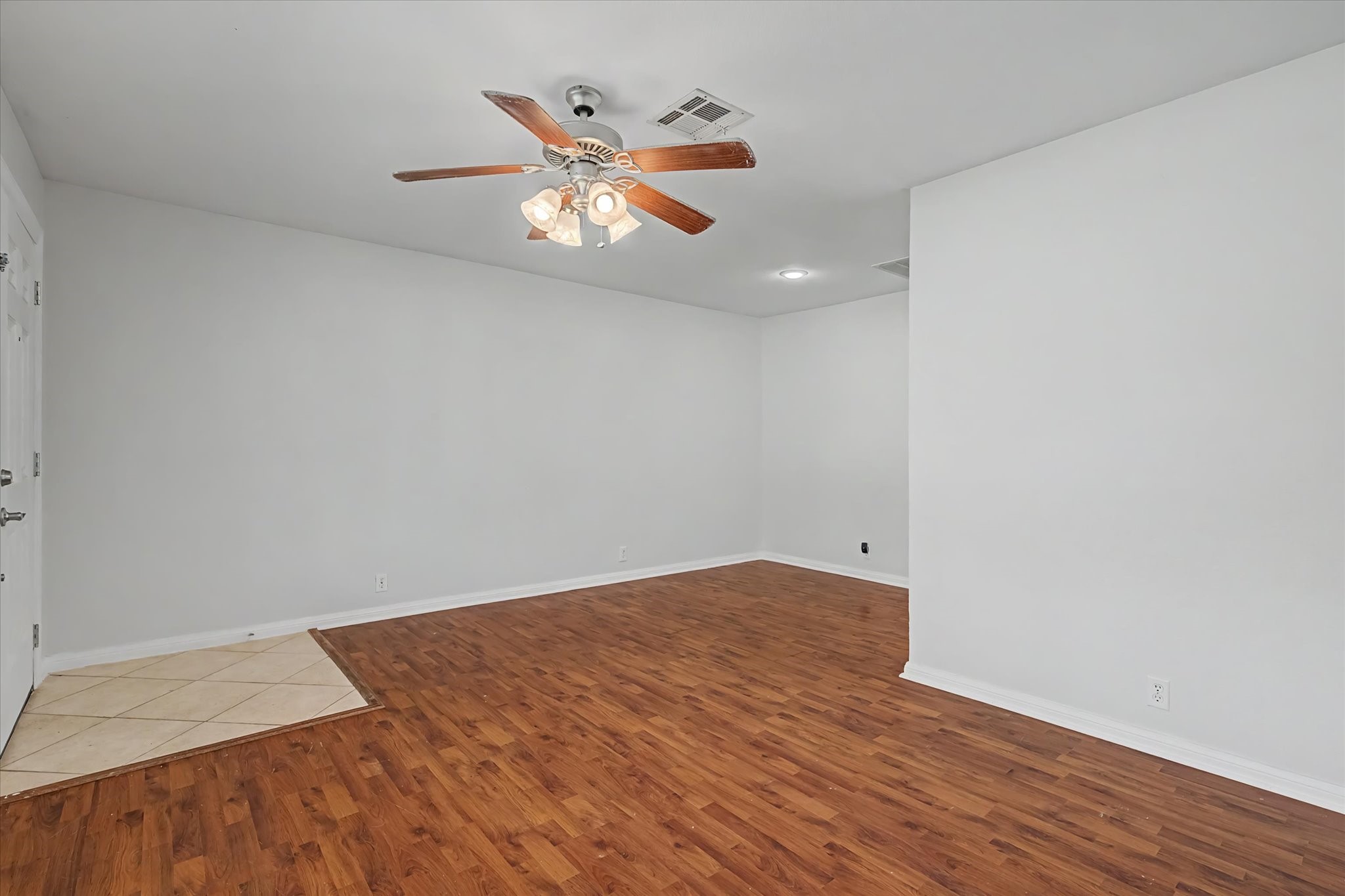413 Farrer Street Angleton, TX 77515 - Photo 5 of 43 an empty room with wooden floor chandelier fan and windows