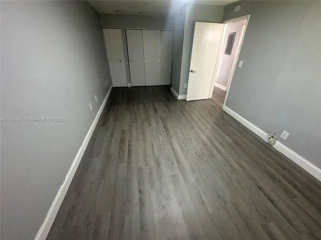 a view of a livingroom with a flesh screen tv wooden floor and window