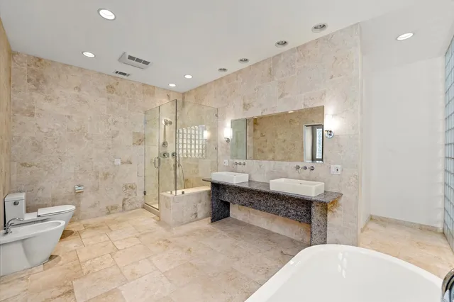 a large bathroom with a tub sink toilet and mirror