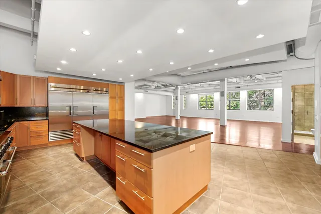 a kitchen with stainless steel appliances granite countertop a sink and a large window