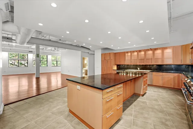 a kitchen with stainless steel appliances granite countertop a large counter top and a stove