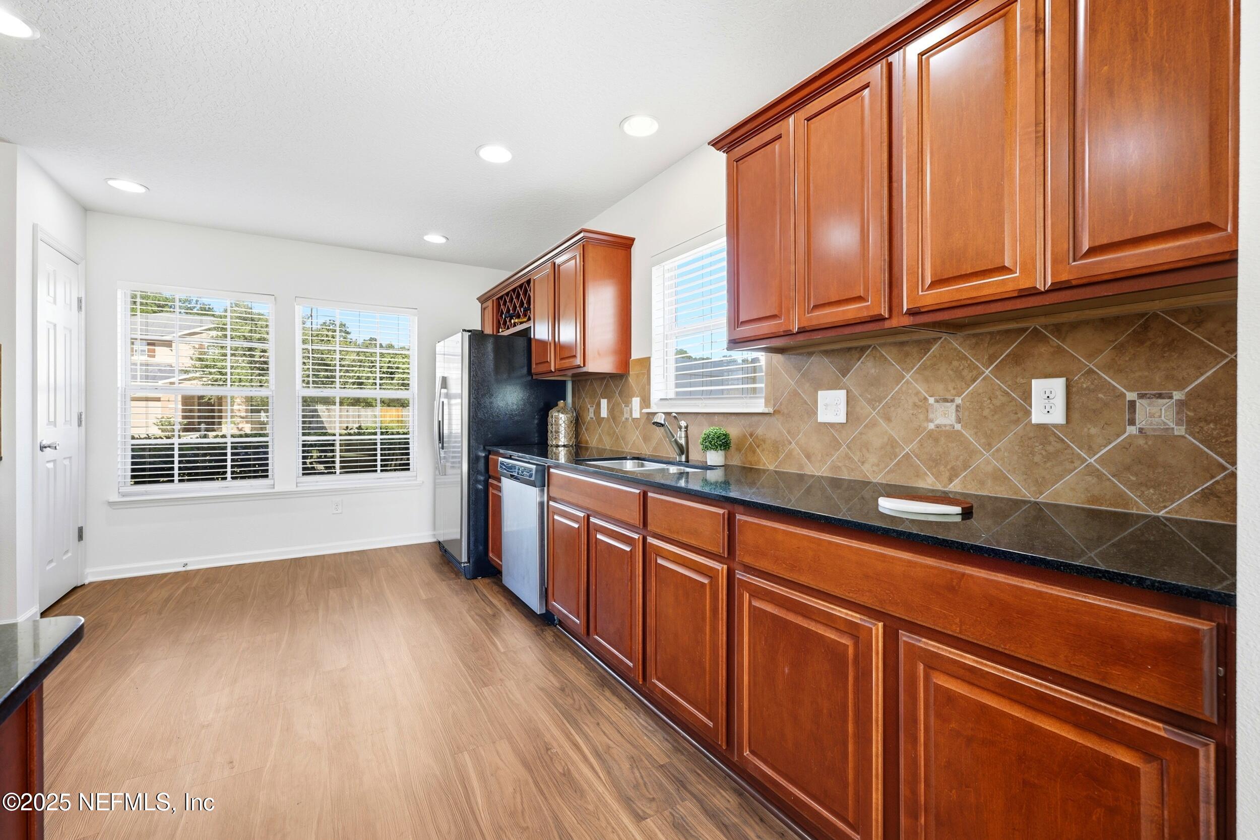 7478 Steventon Way Jacksonville, FL 32244 - Photo 9 of 26 a kitchen with stainless steel appliances granite countertop a sink a stove cabinets and wooden floor