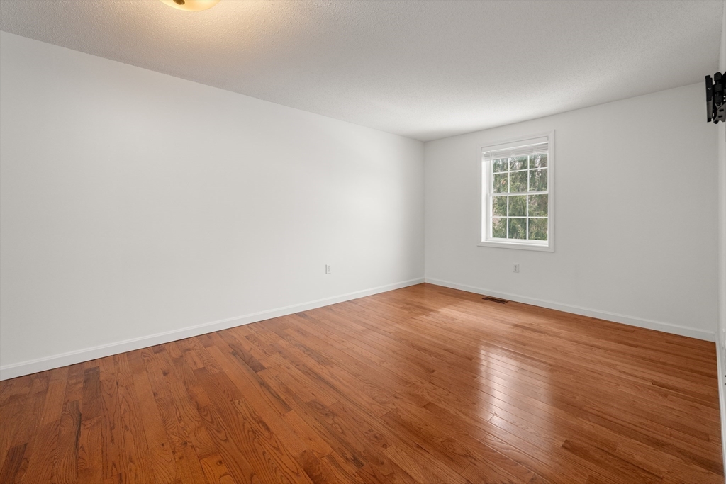 181 High Street, Unit 1 Andover, MA 01810 - Photo 13 of 21 an empty room with wooden floor and windows