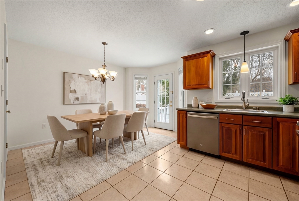 181 High Street, Unit 1 Andover, MA 01810 - Photo 6 of 21 a dining hall with granite countertop a sink dishwasher a dining table and chairs with wooden floor