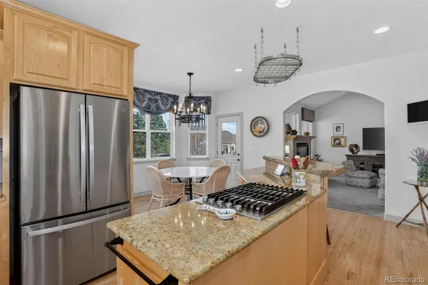 a kitchen with a refrigerator a stove a sink dishwasher and white cabinets with wooden floor