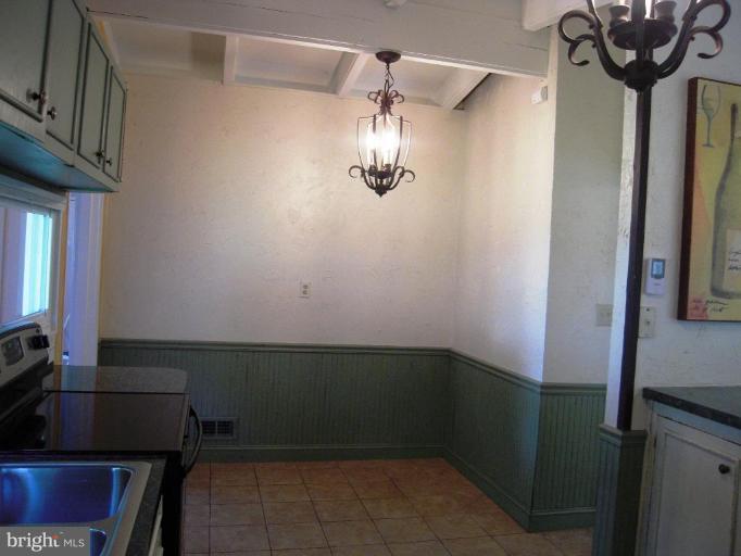 6707 Queens Ferry Road Baltimore, MD 21239 - Photo 17 of 23 a view of a room with rack on the wall and a chandelier