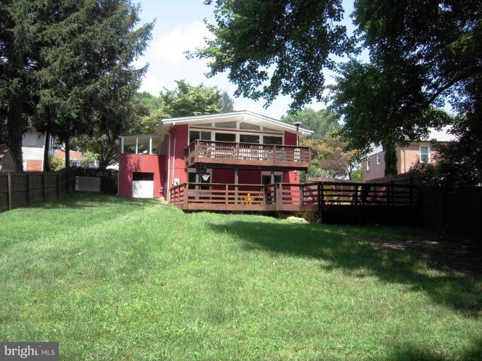 6707 Queens Ferry Road Baltimore, MD 21239 - Photo 18 of 23 a view of a yard with large trees and a barn in it