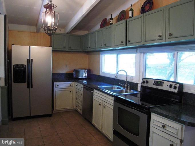 6707 Queens Ferry Road Baltimore, MD 21239 - Photo 7 of 23 a kitchen with stainless steel appliances granite countertop a sink a stove and a refrigerator