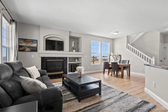 a living room with furniture fireplace and dining table