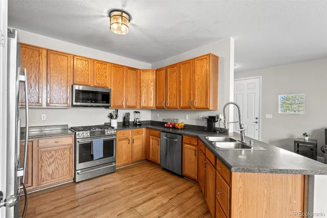 a kitchen with stainless steel appliances granite countertop a sink stove microwave and refrigerator